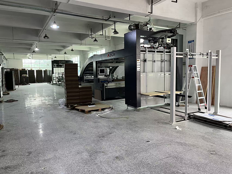 Automatic paper laminating machine at Color Creative Packaging, feeding printed cover paper and greyboard for handmade box production
